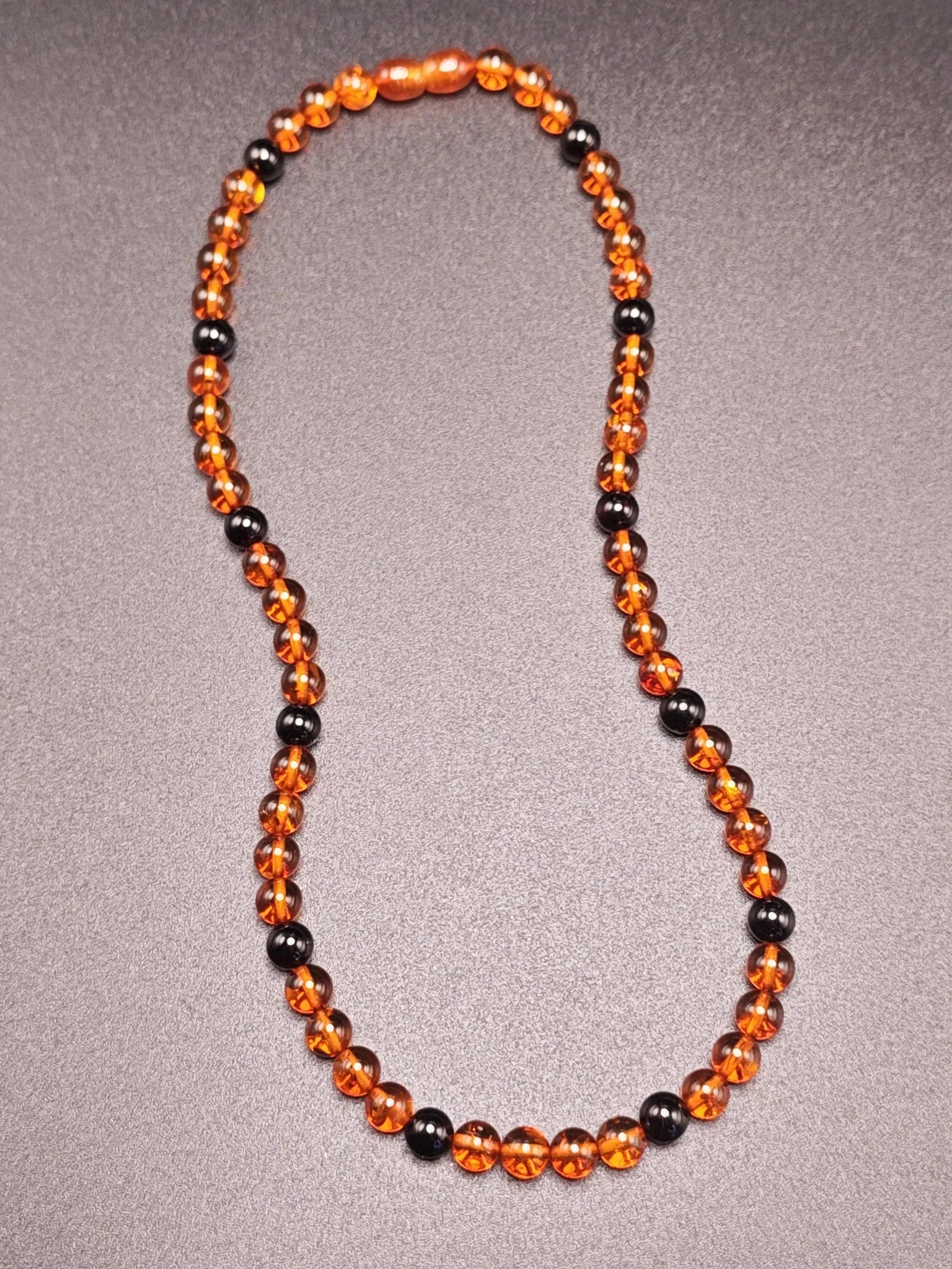 Bernstein-Kette mit orangefarbenen und schwarzen Perlen, handgefertigt aus echtem Ostsee-Bernstein
